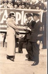 National Apple Week, unidentified woman giving apples to two naval officers, about 1925