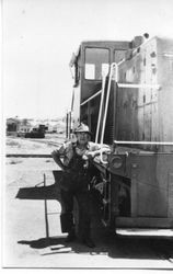 P&SR railroad man Ray Pelton beside a freight engine No. 3, 1960s