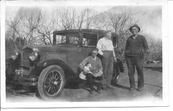 Morris Whitham holding a dog and sitting on the running board of a car, next to Harry Rosebrook (middle) and Will Rosebrook (Harry's father), circa 1930