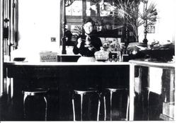 Interior photo a of soda fountain with woman woman behind the counter in Worth's Drugstore in 1903