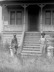 Man and woman posing at the steps of a house, 1920s or 1930s