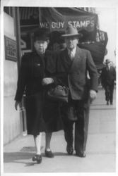 Charles R. and Eva Myers walking down sidewalk, 1940s