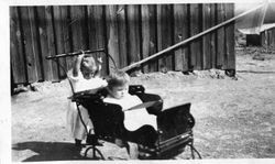 Young Harriet Elvy pushing the carriage of her younger sister Wilma Elvy, about 1919