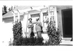 Bunni Myers and her father Charles R. Myers standing in front of a house, about 1940s