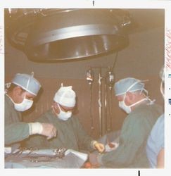 Dr. Ellison and Dr. Horace Sharrocks in the Palm Drive Hospital operating room performing surgery, 1975