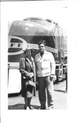 Bunni and George Streckfus standing in front of a Santa Fe locomotive, June 6, 1938