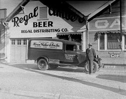 Unidentified man stands beside the Regal Amber beer delivery truck, 1930s in front of Regal distributing building in Sebastopol