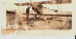 Sam Huck at propeller of biplane, 1920s