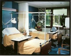 Palm Drive Hospital room with two beds and various pieces of equipment and furniture