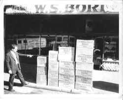 W. S. Borba standing in front of his radio store pointing to boxes of Atwater Kent Radio boxes just delivered, 1920s