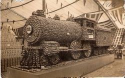 1914 Gravenstein Apple Show display of fireplace with spinning wheel, sponsored by the Jonive District