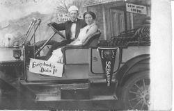 Staged photo of two people in a car at the 1912 Gravenstein Apple Show