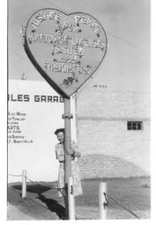 Bunni Streckfus standing next to a Justice of the Peace sign in Reno or Las Vegas, 1950s