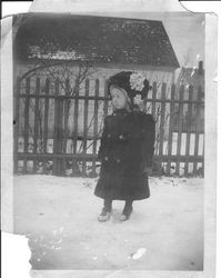 Cornelia E. "Bunni" Myers in winter coat and hat standing outside in the snow, about 1914