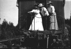 P&SR passenger car with man and two women at the back door, about 1904