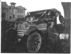 Larry Naumann and an unidentified girl, stand in front of a flag decorated car in front of Analy Union High School in 1922