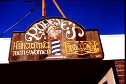 Hand-painted business sign of Popeye's Haircutting and Tobacconist at 217 North Main Street, Sebastopol, California