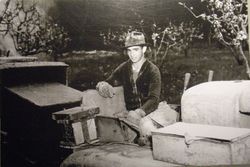 Bill Silva seated on tractor with a sprayer in an apple orchard