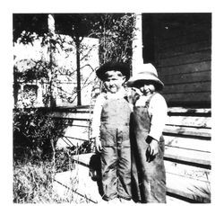 Delbert E. (Deb) Triggs and Billy Robertson, standing on the front steps of a house, about 1913