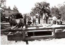 Steve Fowler, Tom Harriman, Mel Davis and others working on sub-floor of the barn during the Burbank Farm barn raising, 1998