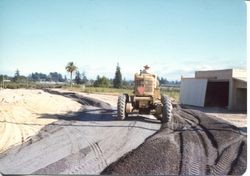 Don Hallberg grading the road in front of the Hallberg Apple stand along Gravenstein Highway North (Highway 116)