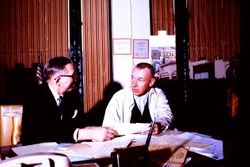 Unidentified government official in his office with another unidentified man, about 1970