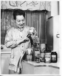 Publicity photo of Redwood Empire apple products being shown by a "housewife" in a kitchen setting