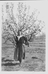 Emma Street Hively, 1931 standing in an orchard in front of a pear tree