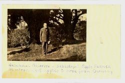 Nathaniel A. Griffith standing in front of several large trees and an apple orchard beyond