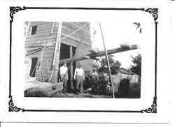 Three men standing next to the well house on the farm of William and Leona Rosebrook in Sebastopol, about 1920