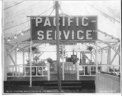 1912 Gravenstein Apple Show display by Pacific Gas & Electric Co., with a large electric sign "Pacific Service" and a display of an "open" house with various electric lights and appliances on display