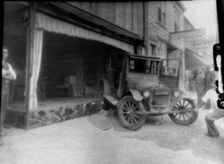 Car wreck with a vintage 1920s car that has ended up in the front window of a downtown unidentified business next door to the The Apple Blossom ice cream and candy shop