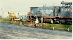 Workmen are removing the P&SR railroad tracks on South Gravenstein Highway 116 near Industrial Avenue and Sparkes Road, about 1984 with the help of a Southern Pacific engine