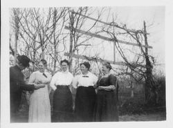 Four of Isaac W. Sullivan's married daughters and an unidentified man standing outside in front of a trellis