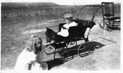 Young Harriet Elvy in front of the carriage of her younger sister Wilma Elvy, about 1919