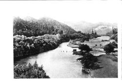 Scene of the Russian River surrounded by redwoods and mountains