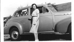 Bunni Cornelia E. Myers Streckfus standing beside car in skirt and sweater, 1940