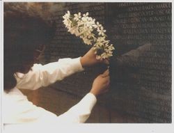 Vicki Clem placing flowers at the location of Edward G. Rainford's name at the Vietnam Veterans Wall--The Moving Wall post, 1984