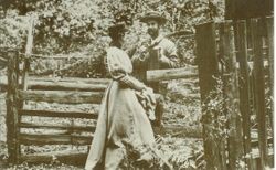 Man and woman standing by split rail fence in Duncans Mills, California, 1893