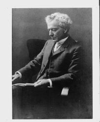 Luther Burbank seated and looking at a magazine