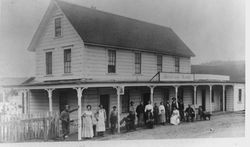 Hotel in Bodega (Murray)? with several people standing and seated in front, 1890s