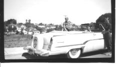 Group of young people with a light colored Lincoln Continental convertible car on Willow Street east of High Street in Sebastopol, 1950s