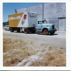 Redwood Empire Apple Products truck with the sign "Rapples" stands beside the O. A. Hallberg & Sons Apple Products cannery in Graton, California, July, 1963