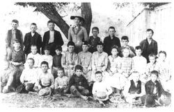 Unidentified group of elementary students with teacher, probably from a rural school, about 1900