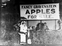 Gravenstein Apple Show clown with small child standing in front of an apple booth