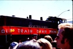 Southern Pacific train with "Our Train Down Main" banner in the Apple Blossom Parade, Sebastopol, California, 1970s