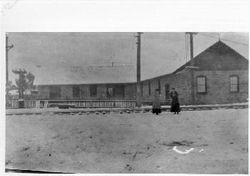 Two women with snowballs in front of the P&SR powerhouse station, Sebastopol, California, January, 1908