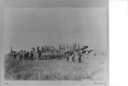 Men and women in field with steam threshing machine