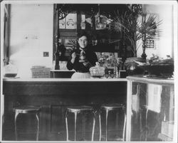 Unidentified woman behind a soda fountain