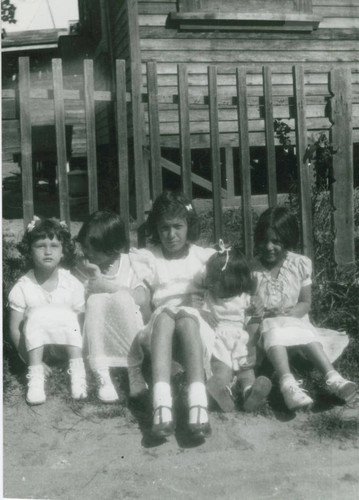 Ernestina Martinez in front of a house on stilts, East Los Angeles, California